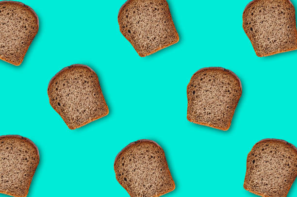 istock Chaotic scattered many rectangular pieces of fresh rye bread on green table on kitchen. Top view. Dieting concept 1092164842
