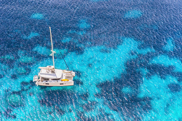 Sailboat yacht catamaran in beautiful Mediterranean bay Sailing boat in a sea, yachting, sailing, travel and active lifestyle concept catamaran sailing boats stock pictures, royalty-free photos & images
