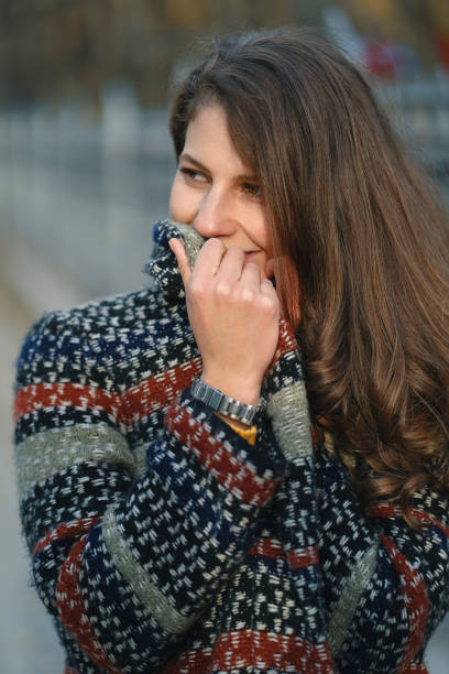istock Young woman hiding her smiling face behind collar 1092169462