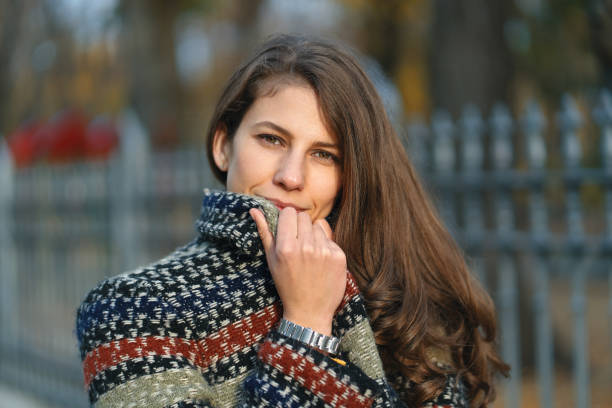 istock Young woman hiding her smiling face behind collar 1092169480