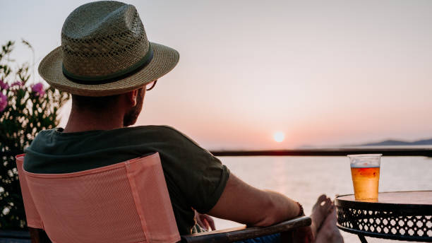 istock Young man enjoying beer and sunset in a beach bar 1092171092