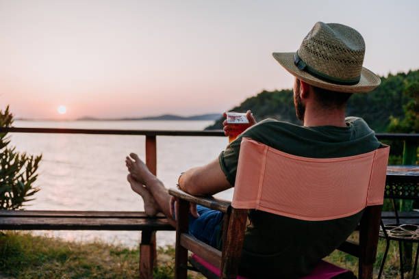 istock Young man enjoying beer and sunset in a beach bar 1092171094