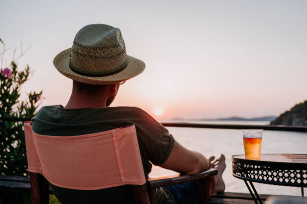 istock Young man enjoying beer and sunset in a beach bar 1092171096