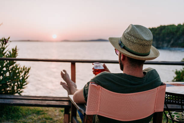 istock Young man enjoying beer and sunset in a beach bar 1092171098