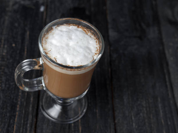 istock Irish coffee glass with foam and cinnamon on wooden table 1092171850