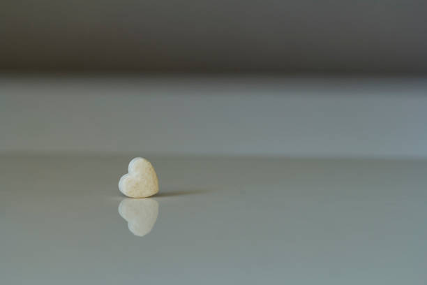 istock small white heart on a glossy background 1092173468