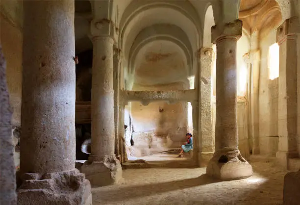 Photo of The interior of the column hall of the old underground church carved into the sandstone rock.