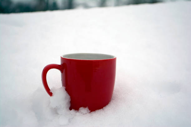 istock Red mug with tea in the snow Winter morning 1092191696