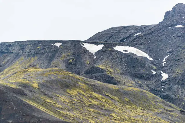 Iceland barren landscape view of rocky mountain on cloudy day on south southern ring road or golden circle with snow ice
