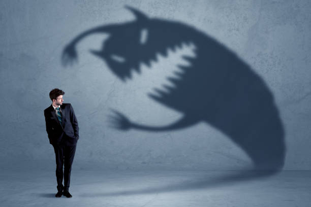 istock Business man afraid of his own shadow monster concept 1092206246