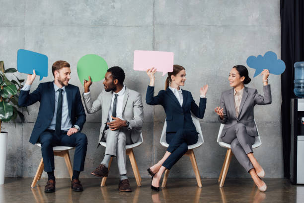 istock happy multiethnic businesspeople holding speech bubbles and thought bubble while sitting in waiting hall 1092210112