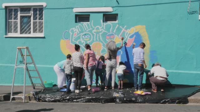 Community painting mural on sunny wall