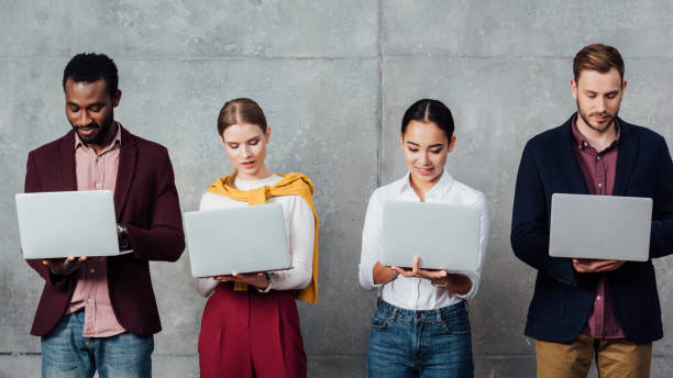 istock focused multiethnic casual businesspeople using laptops in waiting hall 1092216896