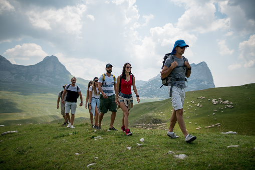 Group of people hiking with travel guide on the mountain