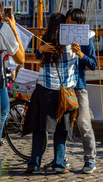 Free hugs for strangers in Copenhagen, Denmark. A Japanese man offers free hugs to passing strangers in Copenhagen, Denmark. He has been to more than 100 countries and is pictured in the Nyhavn region of Copenghagen.