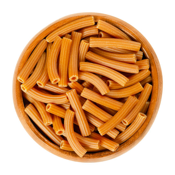 kichererbsen pasta, braune sedanini rigati in holzschale über weiß. - cicer stock-fotos und bilder