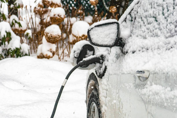 Snow removal of an electric car, Quebec, storm day In Saint-Hugues, Quebec, Canada, Diring a snowfall an electric car is covered with snow. The car is the Chevrolet Bolt. The vehicle is charging. A lot of snow covers the car. montérégie photos stock pictures, royalty-free photos & images