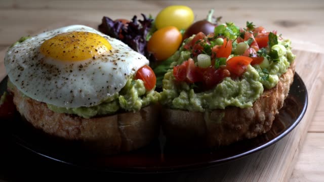 Avocado Toast Topped With Diced Tomatoes Chopped Green Onion Drizzled With Olive Oil And Fried Egg