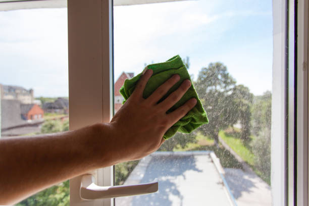 istock A man's hand washes the window with a green rag 1092236608