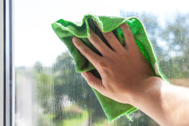 istock A man's hand washes the window with a green rag 1092236626