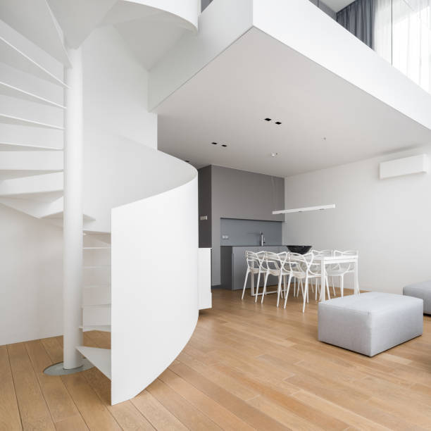 wnętrze domu ze spiralnymi schodami - table chair white curve zdjęcia i obrazy z banku zdjęć