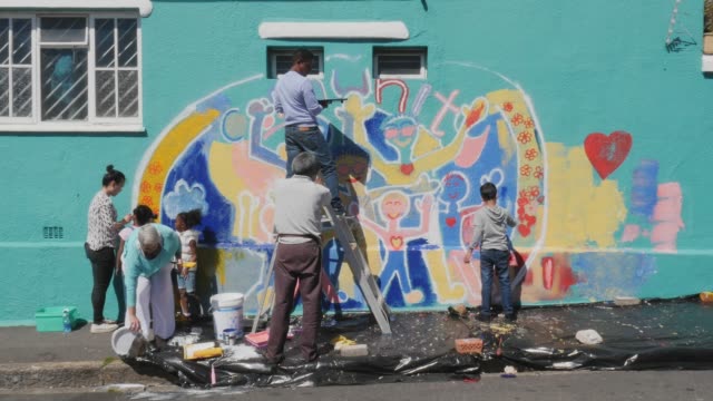 Community painting mural on sunny wall