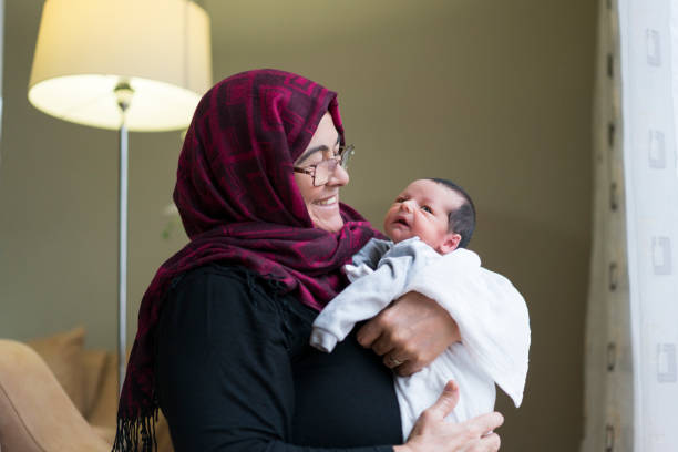 nonna che tiene in braccio un neonato - baby grandparent newborn grandmother foto e immagini stock