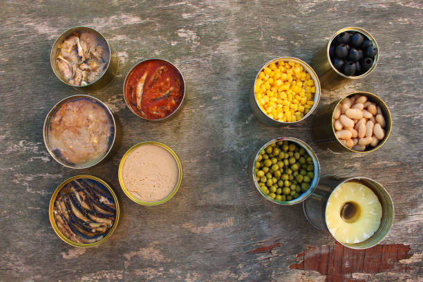 istock Different open canned food on old wooden background. Top view. Flat lay. 1092257186