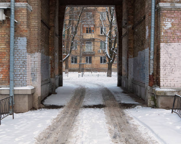 arc path to the courtyard of residential building with trace leading lines left by car on fresh snow at winter
