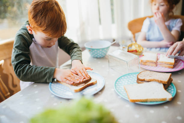 Making Sandwiches for Lunch Two children making their sandwiches for lunch. making a sandwich stock pictures, royalty-free photos & images