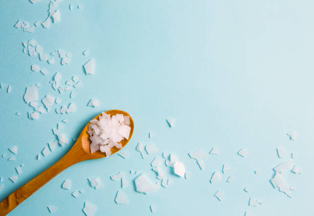 Magnesium vitamin flakes on wooden spoon.