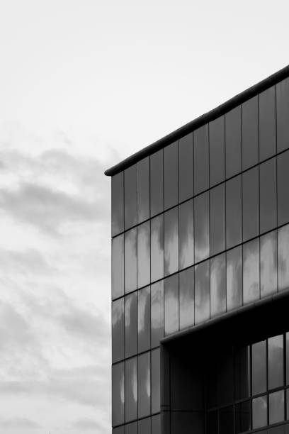 istock Modern building with curtain wall glass facade with cloudy sky reflections and background, black and white 1092267466