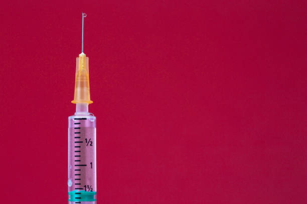 istock Syringe isolated on a red background. Clipping path. 1092268838