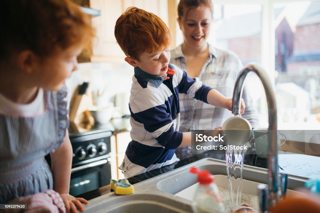 S’amuser à laver la vaisselle - Photo de Famille libre de droits