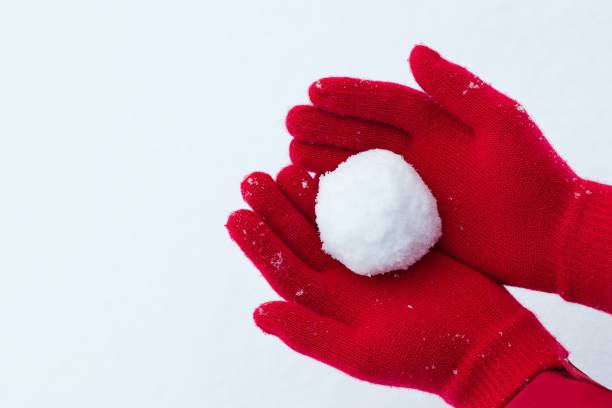 mãos nas luvas vermelhas segurando a bola de neve - glove winter wool touching - fotografias e filmes do acervo