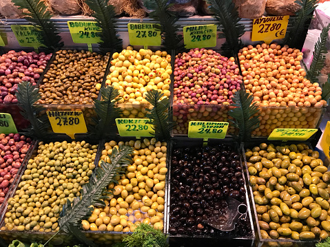 From a high angle perspective, an assortment of dried nuts is showcased on a market stall, providing a tempting display of variety for potential buyers.