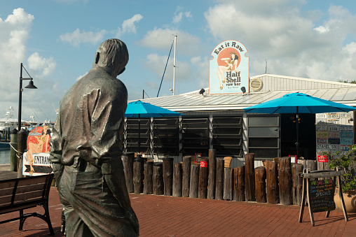 Key West, Florida, United States - August 15, 2018: View of a statue and a restaurant by the marina harbor in Key West, Florida Keys - United States