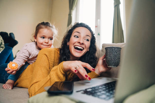 istock Mother and daughter using laptop on sofa 1092293258