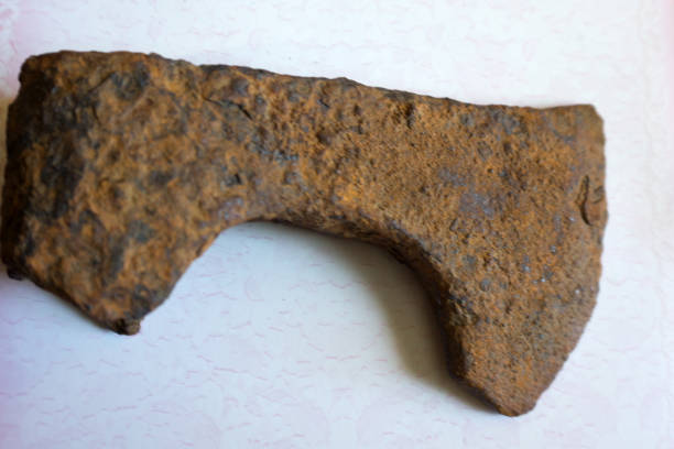 istock Photo depicts iron rusty but very sharp old wooden ax blade, placed on a timber with chopping trace. Axeman equipment tool concept. Ax and ax handle, woodworking. Deforestation by a sharp axe. 1092293708