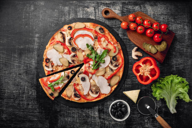 istock Pizza with cheese, ham, pickled cucumbers, meat and olives on chalk board. 1092293958