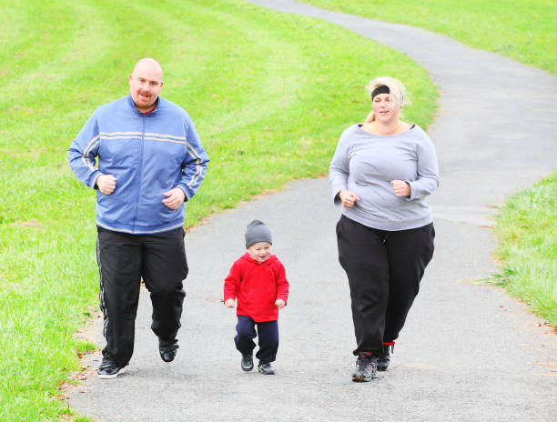 Overweight parents with her son running together. Healthy lifestyle and slimming theme.