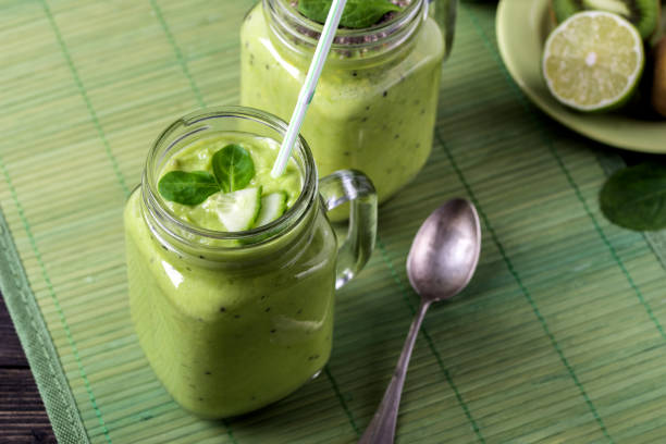 istock Green smoothie on green background made by avocado, lemon and kiwi. 1092305908