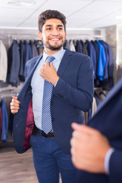 istock Young man is trying on tie in front of the mirror 1092320408