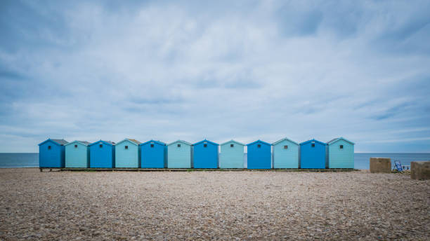 Blue beach houses in the UK Blue beach holiday house by the English Channel on Jurassic coast in Charmouth, Dorset, United Kingdom, UK. British summer holidays, hilly countryside, beach summer destination. christchurch england photos stock pictures, royalty-free photos & images