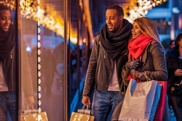 beautiful black couple at christmas shopping - christmas shopping imagens e fotografias de stock
