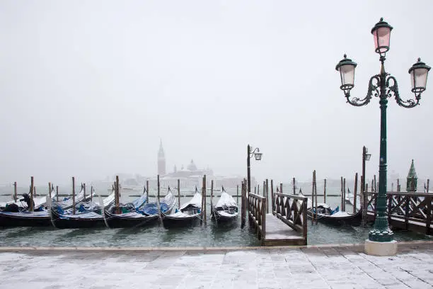 Photo of Snow on Venetian gondolas, St. Mark square, Venice, Italy
