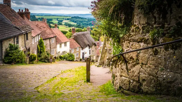 Old limestone English houses at Gold Hill in Shaftesbury is an authentic place in the South of the UK. English countryside in Dorset. Photo with selective focus.