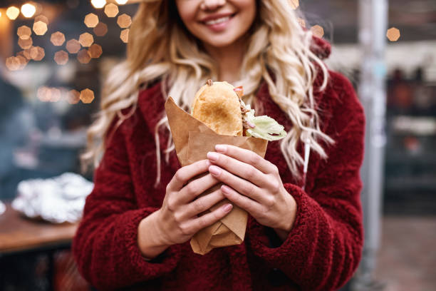 primo primo tempo di giovane donna bionda che mangia un panino al sandwich bar - piazza delle vettovaglie foto e immagini stock