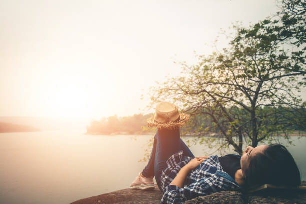 istock Woman Lying On Rock Against Lake 1092355682