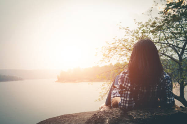 istock Woman Reclining On Rock Against Lake 1092355694